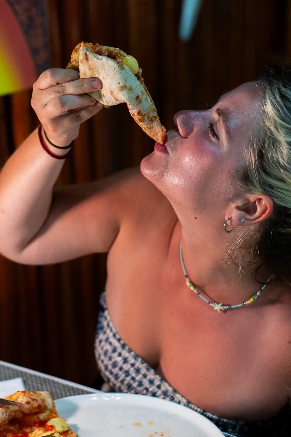 Cliente che assaggia con gusto una fetta di pizza